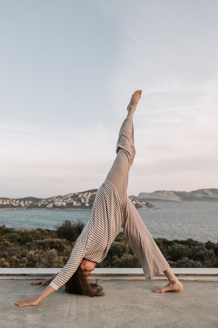 A woman practicing yoga on a terrace with a stunning sea view in Antalya, Turkey at sunset.